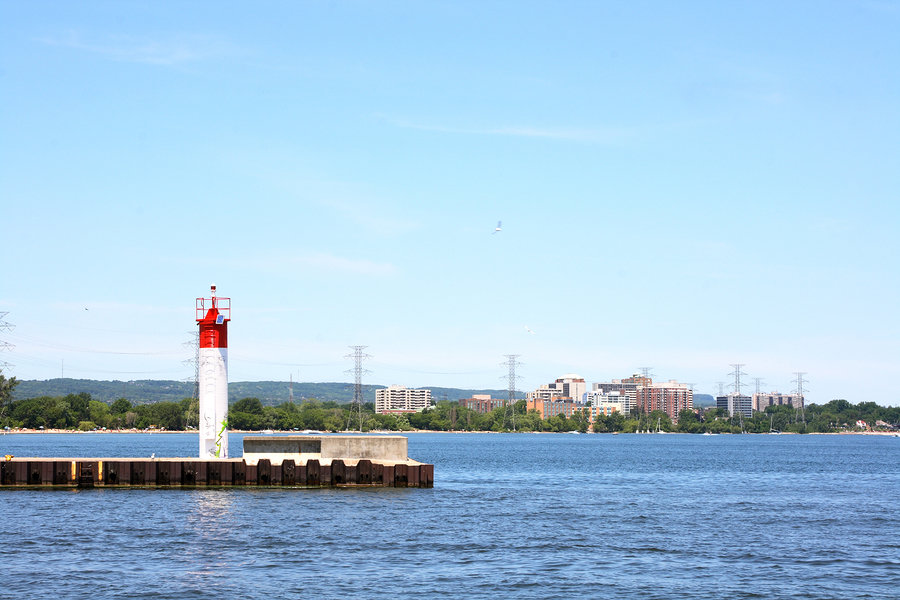 Shoreline in front of Lake Ontario with navigation light of Burlington Canal